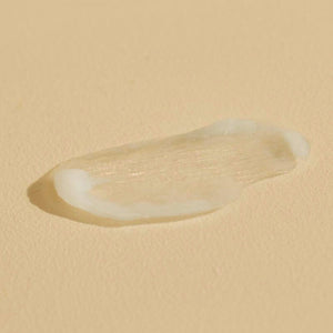 Close-up of a smooth, creamy texture sample of Citrus Cardamom HAND SERUM | Sparitual on a neutral background, highlighting its skincare qualities.