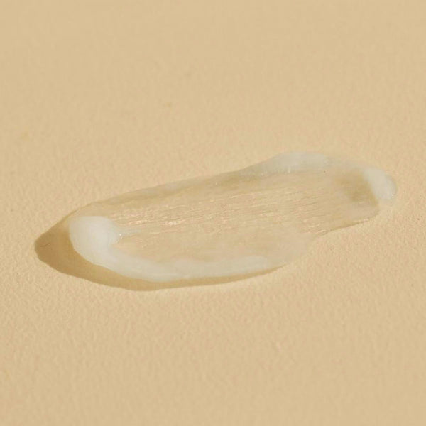 Close-up of a smooth, creamy texture sample of Citrus Cardamom HAND SERUM | Sparitual on a neutral background, highlighting its skincare qualities.