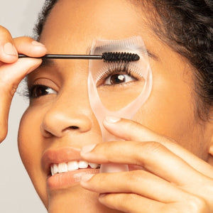 Close-up of a person using the Lash Guard & Comb | Tweezerman to separate and groom eyelashes while applying mascara for a precise and clump-free look.