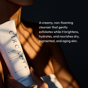 Person holding a tube of Amandola Milk Cleanser | Circadia with soft sunlight and shadows, highlighting the creamy, non-foaming skincare product for hydrating and nourishing dry, aging skin.