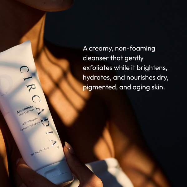 Person holding a tube of Amandola Milk Cleanser | Circadia with soft sunlight and shadows, highlighting the creamy, non-foaming skincare product for hydrating and nourishing dry, aging skin.
