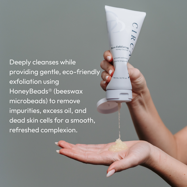 Hand squeezing a clear gel cleanser from a white tube labeled Micro-Exfoliating Honey Cleanser - 2 oz | Circadia onto the palm against a neutral background.