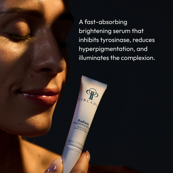 Woman holding a tube of Radiant Brightening Serum (Formerly Bright White Serum) | Circadia with soft sunlight on her face, promoting skincare that reduces hyperpigmentation and brightens complexion.