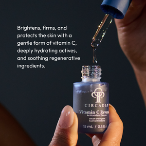 Close-up of a hand holding a bottle of Vitamin C Reversal Antioxidant Serum | Circadia with a dropper dispensing serum, highlighting its brightening and hydrating skincare benefits.