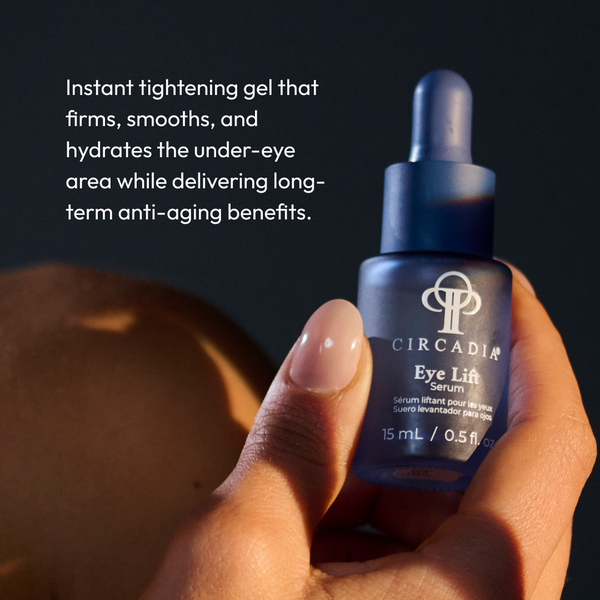 Hand holding a blue frosted glass dropper bottle of Eye Lift Serum (formerly Emergency Eye Lift) | Circadia with text describing it as an instant tightening gel that firms, smooths, and hydrates the under-eye area while delivering long-term anti-aging ben