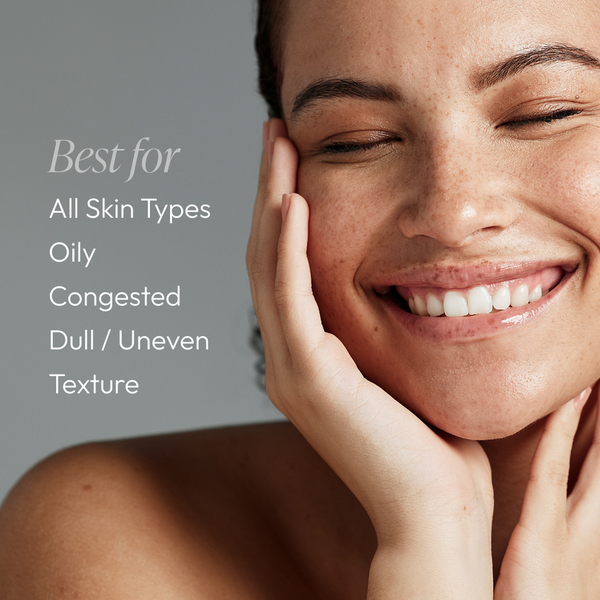 Close-up of a smiling woman with clear skin touching her face next to text that lists skin types best for Micro-Exfoliating Honey Cleanser - 2 oz | Circadia, including all skin types, oily, congested, dull, and uneven texture.