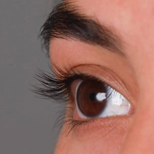 Close-up of a brown eye with long, curled eyelashes enhanced by the Deluxe Heated Eyelash Curler | Chella, showcasing natural and lifted lashes for a polished look.