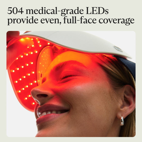 A woman wearing the Theraface Mask Glo | Therabody with red medical-grade LEDs glowing across her face, demonstrating full-face skincare treatment.