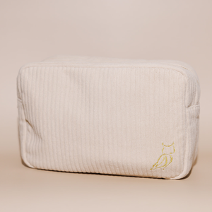 Soft beige textured fabric pouch with a subtle embroidered owl detail, designed for the Luxe Bath Ritual Kit | Live Love Spa, perfect for skincare and body care storage.