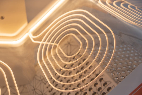 Close-up view of glowing heating elements inside a wellness device designed for relaxation and recovery, highlighting the smooth curved lines and warm light of the Ammortal Chamber | Ammortal.