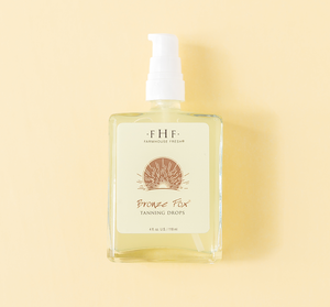 Bottle of Bronze Fox® Tanning Drops | Farmhouse Fresh with a pump dispenser against a soft yellow background, highlighting skincare and body care wellness.