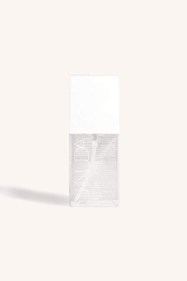 Clear spray bottle with white cap labeled Face Tan Water - Dark | NUDA, showcasing skincare product against light neutral background for body care and wellness.