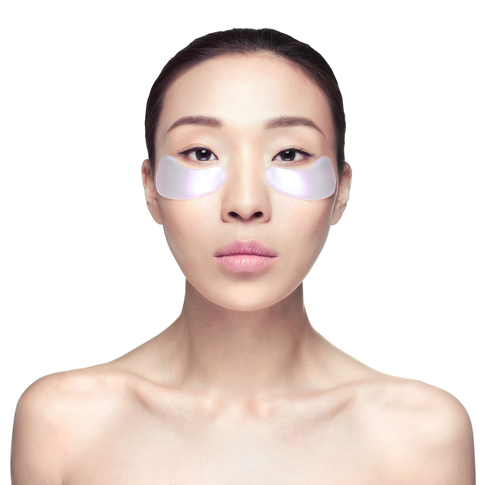 Young woman with smooth skin wearing iridescent eye masks under her eyes, promoting skincare and wellness with Diamond Radiance Eye Mask - 6 pack | Knesko.
