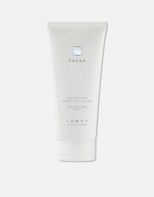 White tube of Age Defying Probiotic Lotion | Zents with minimalist design, featuring organic shea and lotus for skincare and wellness.