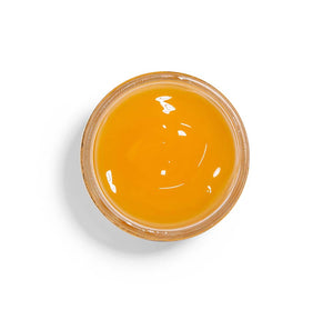 Top view of a smooth golden gel in a clear container from the Honey I’m Smooth Limited Edition Set | Farmhouse Fresh, showcasing skincare product texture.