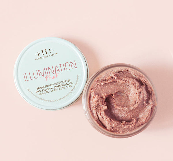Open jar of Illumination Fruit Professional Strength Brightening Fruit Acid Peel Mask | Farmhouse Fresh showing creamy textured pink peel mask on a light pink background.