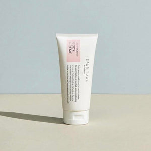 A minimalist tube of Jasmine Tuberose BODY CRÈME | Sparitual standing on a neutral surface with soft natural lighting, highlighting skincare and body care wellness.