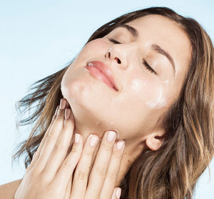 Woman gently applying Kale Water Weightless Moisturizer | Farmhouse Fresh to her glowing face, showcasing skincare hydration and wellness.