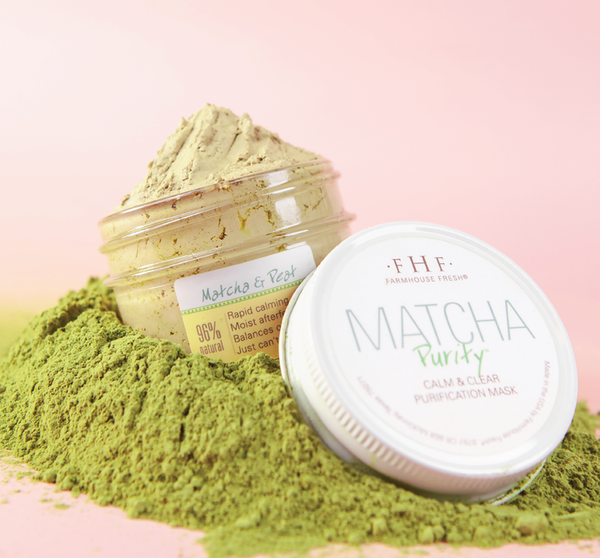 Open jar of Matcha Purity™ Calm & Clear Purification Mask | FarmHouse Fresh with green matcha powder spilled around it, highlighting natural skincare ingredients and calming effects.