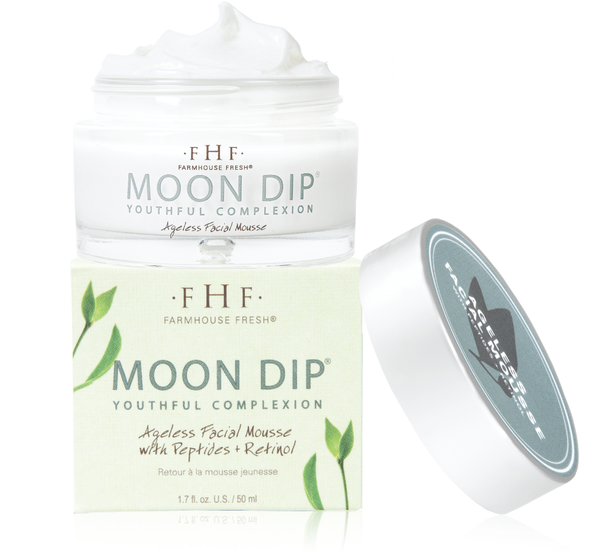Open jar of Moon Dip® Youthful Complexion Ageless Facial Mousse with Peptides + Retinol | Farmhouse Fresh showing creamy white mousse next to its box and silver lid.