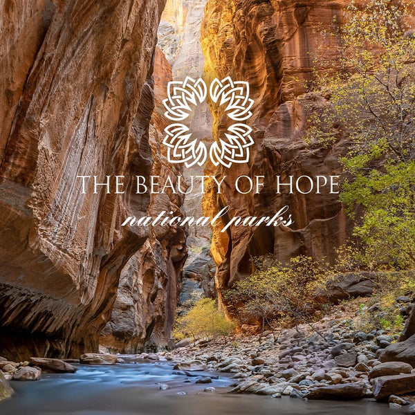 Scenic canyon landscape with a flowing river and autumn foliage, featuring overlay text "THE BEAUTY OF HOPE national parks" related to Glacier 8oz Candle | The Beauty of Hope.