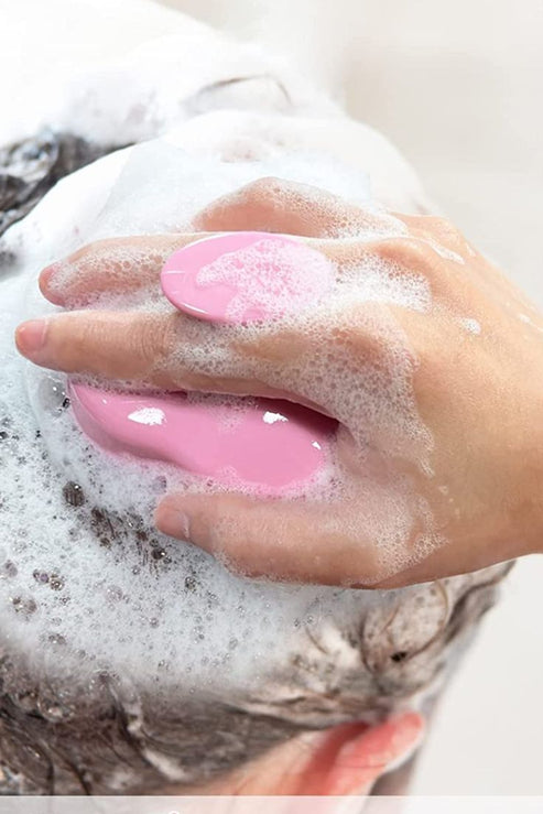 Hand using a pink Scalp Scrubber [Revitalizing Scalp Massager] | Dreambox Beauty to massage and cleanse a lathered scalp, promoting wellness and skincare.