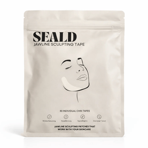 Minimalist beige packaging of Jawline Sculpting Patches | Seald™ Wellness featuring a simple line drawing of a woman's face with a patch applied to the chin area for skincare and facial contouring.