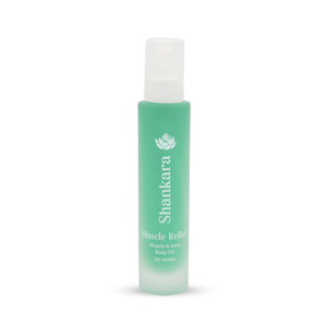 A green frosted glass bottle of Muscle Relief Oil | Shankara, designed for muscle and joint body care, featuring a white spray cap and minimalist text branding.