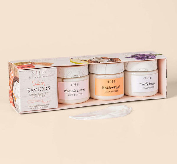 A boxed set of Skin Saviors Shea Butter Sampler | Farmhouse Fresh featuring three jars of creamy shea butter in soft pastel colors, displayed with a dollop of the product on a light background.