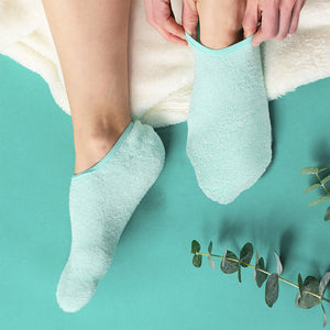 Person putting on light blue Sleep On It Overnight Moisturizing Gel Socks | Barefoot Scientist designed for skincare and hydration during sleep.