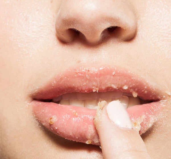 Close-up of a person exfoliating their lips with a gentle scrub, demonstrating the Strawberry Wine 2-Step Luscious Lip Kit | FarmHouse Fresh for smooth, healthy lip care.
