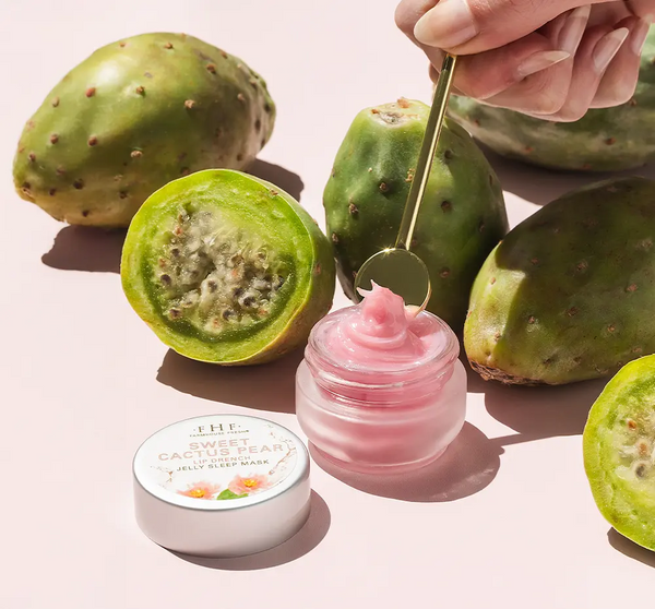 Sweet Cactus Pear Lip Drench Jelly Sleep Mask | Farmhouse Fresh pink jelly balm in a small jar with a gold spatula and fresh green cactus pear fruit halves on a light background, highlighting skincare and wellness.