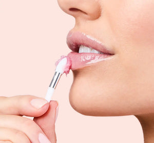Close-up of a woman applying Sweet Cactus Pear Lip Drench Jelly Sleep Mask | Farmhouse Fresh to her lips with a small applicator, highlighting smooth and hydrated skin.