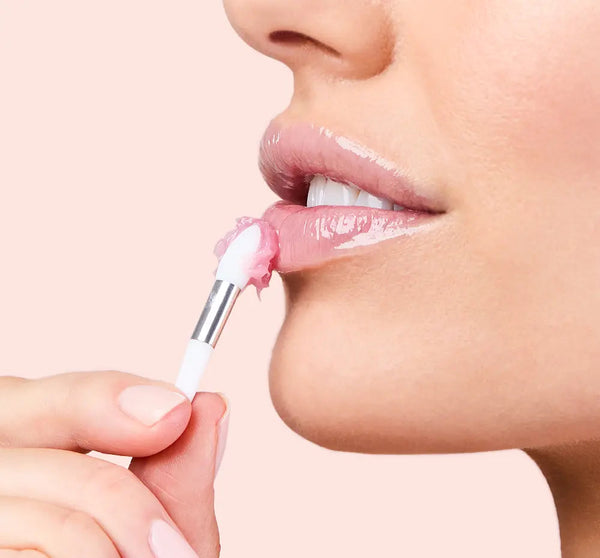 Close-up of a woman applying Sweet Cactus Pear Lip Drench Jelly Sleep Mask | Farmhouse Fresh to her lips with a small applicator, highlighting smooth and hydrated skin.