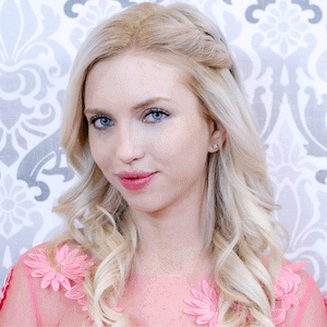 Close-up portrait of a woman with flawless skin and light blonde hair styled in loose curls, showcasing the natural look enhanced by Under Cover Concealer | Pretty Vulgar.