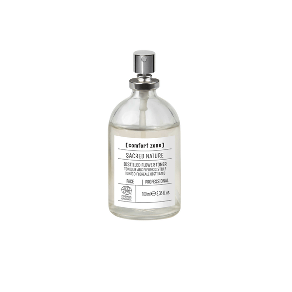 Clear glass spray bottle containing a floral toner with a silver spray nozzle labeled Sacred Nature Distilled Flower Toner Professional | [ comfort zone ] for skincare use