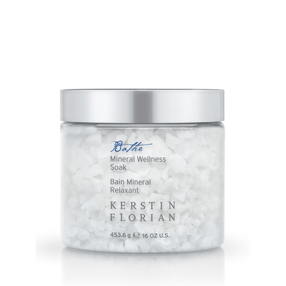 Clear jar of coarse white bath salts labeled Mineral Wellness Soak | Kerstin Florian with a silver lid, designed for skincare and body care wellness routines.