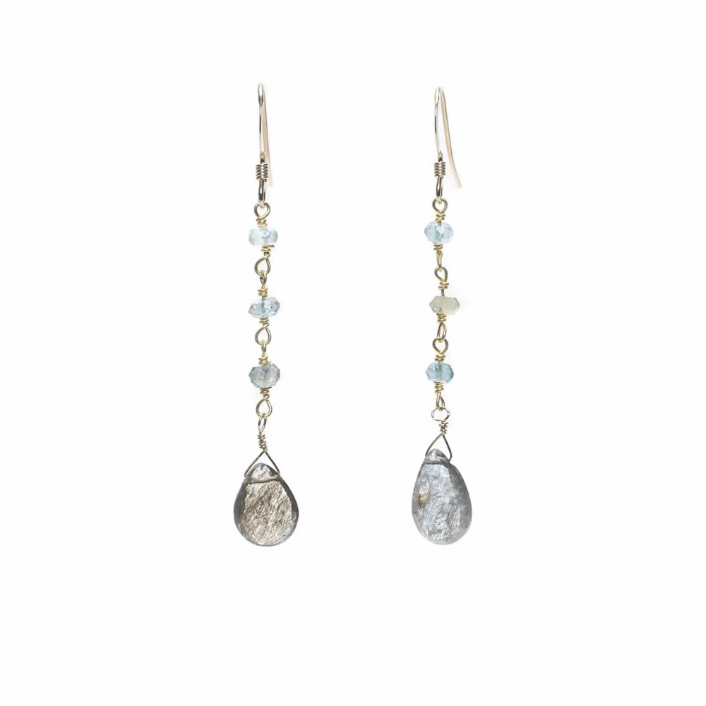 Pair of delicate drop earrings featuring light blue gemstones and teardrop-shaped metallic stones, called Alice Gemstone Earrings | Liv & B.
