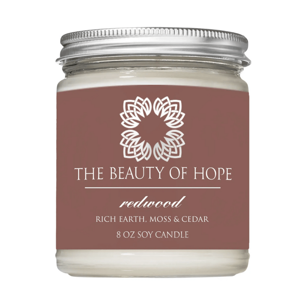 Redwood 8oz Candle | The Beauty of Hope soy candle with a scent blend of rich earth, moss, and cedar in a clear glass jar with a silver lid.