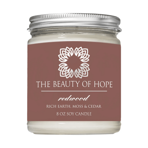 Redwood 8oz Candle | The Beauty of Hope soy candle with a scent blend of rich earth, moss, and cedar in a clear glass jar with a silver lid.