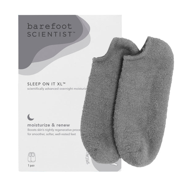 Pair of soft gray moisturizing gel socks displayed next to packaging labeled Sleep On It XL by Barefoot Scientist, designed for skincare and overnight foot hydration, Sleep On It Overnight Moisturizing Gel Socks | Barefoot Scientist.