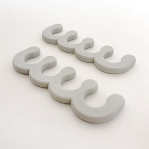 Two pairs of gray silicone toe separators for pedicures, branded with Spaced Out | Barefoot Scientist, designed to promote foot wellness and comfort.