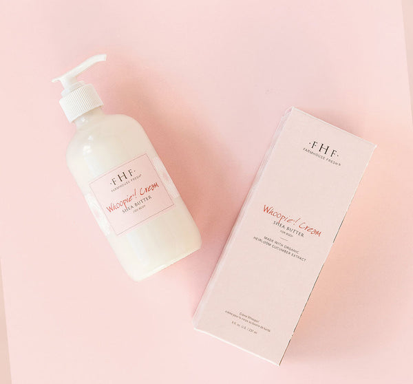 Bottle and packaging of Whoopie® Cream Shea Butter | Farmhouse Fresh skincare product on pale pink background for body care and wellness.