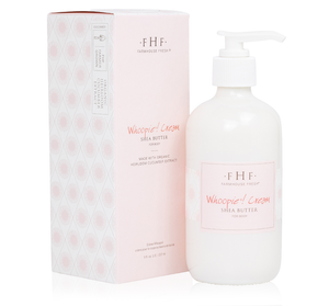 A pump bottle of Whoopie® Cream Shea Butter | Farmhouse Fresh with a matching pink box featuring skincare branding and organic heirloom cucumber extract for body care.