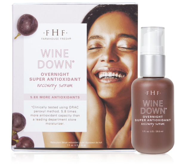 Packaging and bottle of Wine Down® Overnight Super Antioxidant Recovery Serum | Farmhouse Fresh featuring a smiling woman and grape illustrations, promoting skincare recovery.