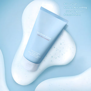 Tube of Calming Clear Acne Foam Cleanser | Leaders resting on a white viscous foam background, highlighting its acne relief and skin-soothing properties in a clean, minimalist setting.