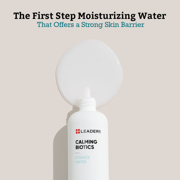 White bottle of Calming Biotics Essence Water | Leaders with clear moisturizing water spilled behind it on a beige background, highlighting its role in strengthening the skin barrier.