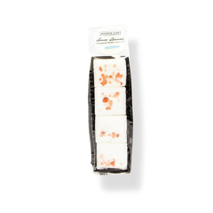 Packaged set of four white Shower Steamer | Essence One cubes with orange speckles on top, designed for a refreshing and aromatic wellness shower experience.