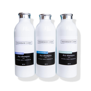 Three white bottles of Dry Shampoo | Essence One in lavender, unscented, and morning calm variants with silver caps, promoting a natural, safe, and therapeutic hair care solution.
