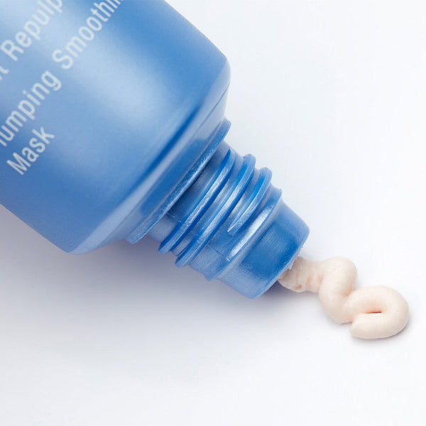 Close-up of blue tube dispensing creamy texture of Expert Youth Mask | Phytomer, highlighting skincare product suitable for facial rejuvenation and smoothing.